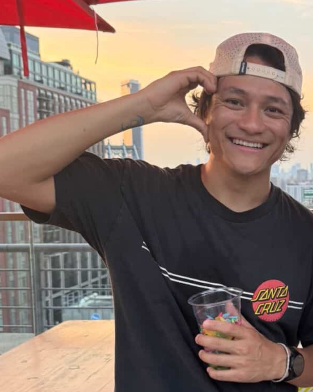 Josh Nguyen smiling on a rooftop in New York at sunset